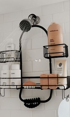 a bathroom shelf with soaps, shampoo and other items on it in front of a white tiled wall