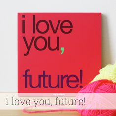 a red sign that says i love you, future next to yarn and ball of yarn