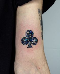 a tattoo on the arm of a person with a four - leaf clover in it