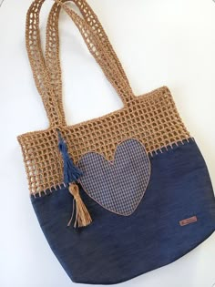 a blue purse with a heart on the front and tassels hanging from it