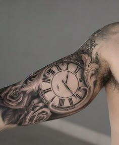 a man's arm with a clock tattoo on it