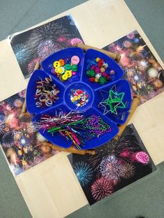 a blue plate topped with lots of colorful buttons and sprinkles on top of a wooden table