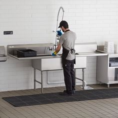 a man is washing his hands in the kitchen sink with a sprayer on it