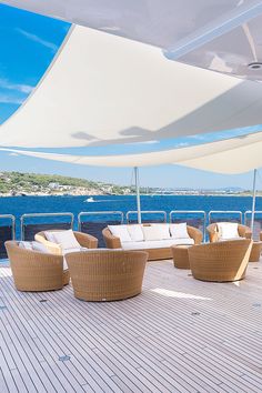 an outdoor seating area on the deck of a boat with blue water in the background