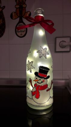 a lighted bottle with a snowman on it