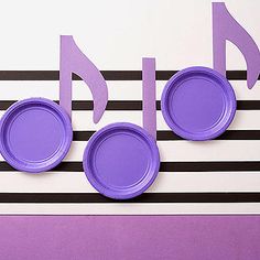 purple paper plates with musical notes on them are arranged in the shape of music notes