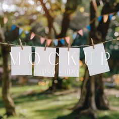 a sign that says mock mock up hanging from a line in the grass with bunting