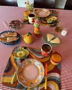 the table is set with plates, cups and food