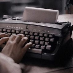 a person typing on an old fashioned typewriter