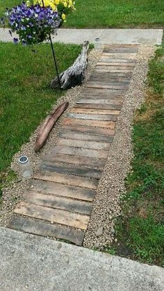 a wooden walkway made out of pallets in the grass