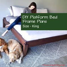 a woman laying on top of a bed next to two dogs