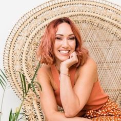 a woman sitting in a chair smiling at the camera