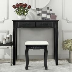 a black vanity table with a mirror and stool