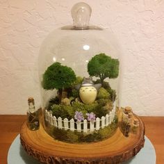 there is a glass dome with trees and animals in it on top of a table