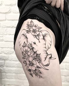 an elephant with flowers on it's thigh