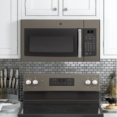 a stove top oven sitting inside of a kitchen next to white cabinets and counter tops