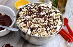 a bowl filled with marshmallows and chocolate drizzled on top