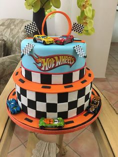 a three tiered cake decorated with hot wheels and cars on it's sides