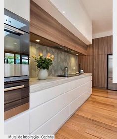 a modern kitchen with wood floors and white cabinets