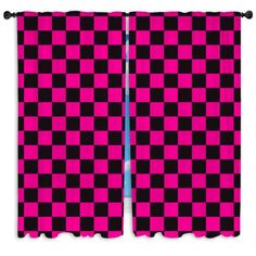 two pink and black checkered curtains hanging on a wall