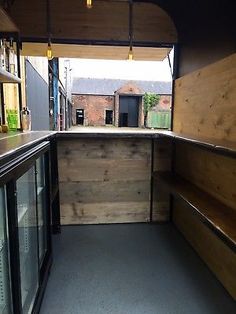 the inside of a food truck with lots of shelves and glass doors on both sides