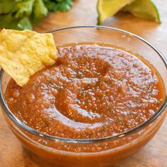 a glass bowl filled with salsa and a tortilla chip