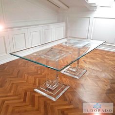 an empty room with wooden floors and a glass table on the floor in front of it