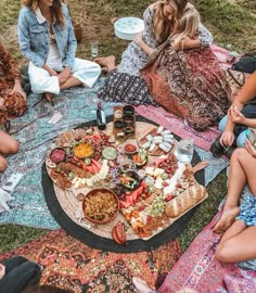 a group of people sitting around a table with food on it