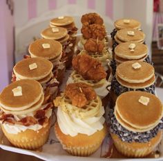 a plate topped with lots of different types of cakes and muffins on top of each other