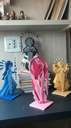 three paper sculptures sitting on top of a desk