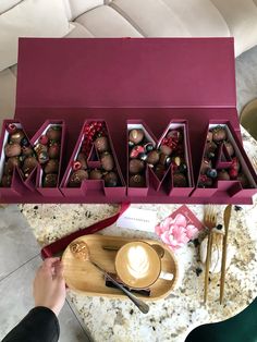 a person is holding a box of chocolates with the word mama spelled out in it