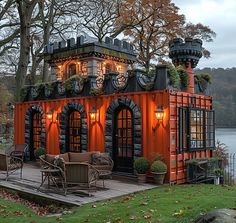 an orange and black house with lots of windows on the roof is lit up at night