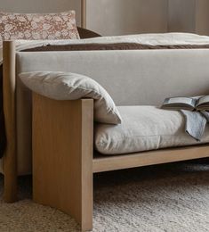 a bed with a wooden frame and pillows on it's headboard, in a bedroom