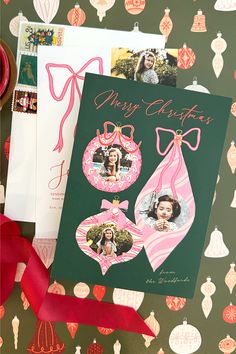 a christmas card with two ornaments and a red ribbon next to it on a green background