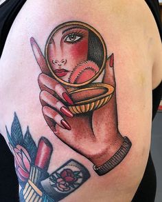 a woman's arm with a tattoo on it and a magnifying glass in her hand