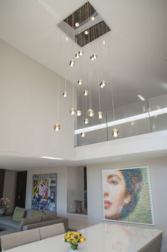 a living room filled with furniture and a chandelier hanging from the ceiling over a white table