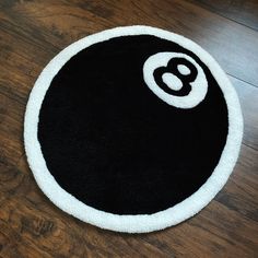 a black and white round rug with the number eight on it's center piece