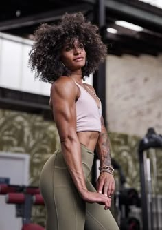 an image of a woman posing for the camera in her gym gear and showing off her muscles