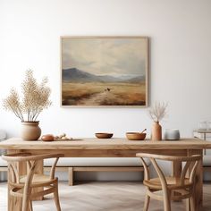 a painting hanging on the wall above a wooden table