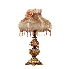 a lamp with a flower on top of it and a shade over the base that is gold