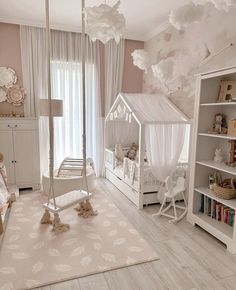 a baby's room with a canopy bed and white furniture