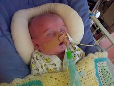 a baby in a crib with an oxygen tube attached to his nose