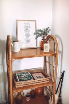 a wooden shelf with pictures and plants on it