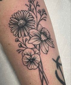 a black and white flower tattoo on the right arm with an anchor in the background