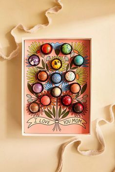 a card with an image of flowers and eggs on it, hanging from a string