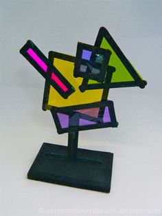 a sculpture made out of stained glass on top of a black stand with a white background