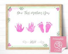 pink handprinted baby's first mother's day sign with the words, our