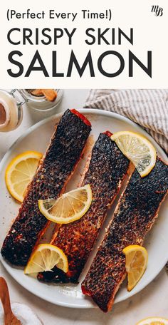 two fish fillets on a plate with lemons and spices next to the plates