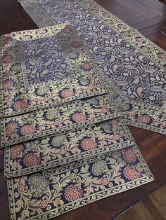 three rugs laid out on the floor in front of a fireplace with wood floors