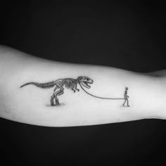 a man is pulling a dinosaur on a string